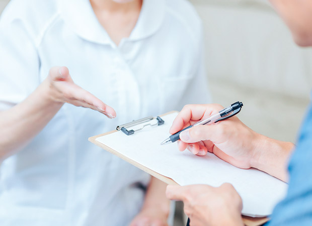 問診票に記入している患者